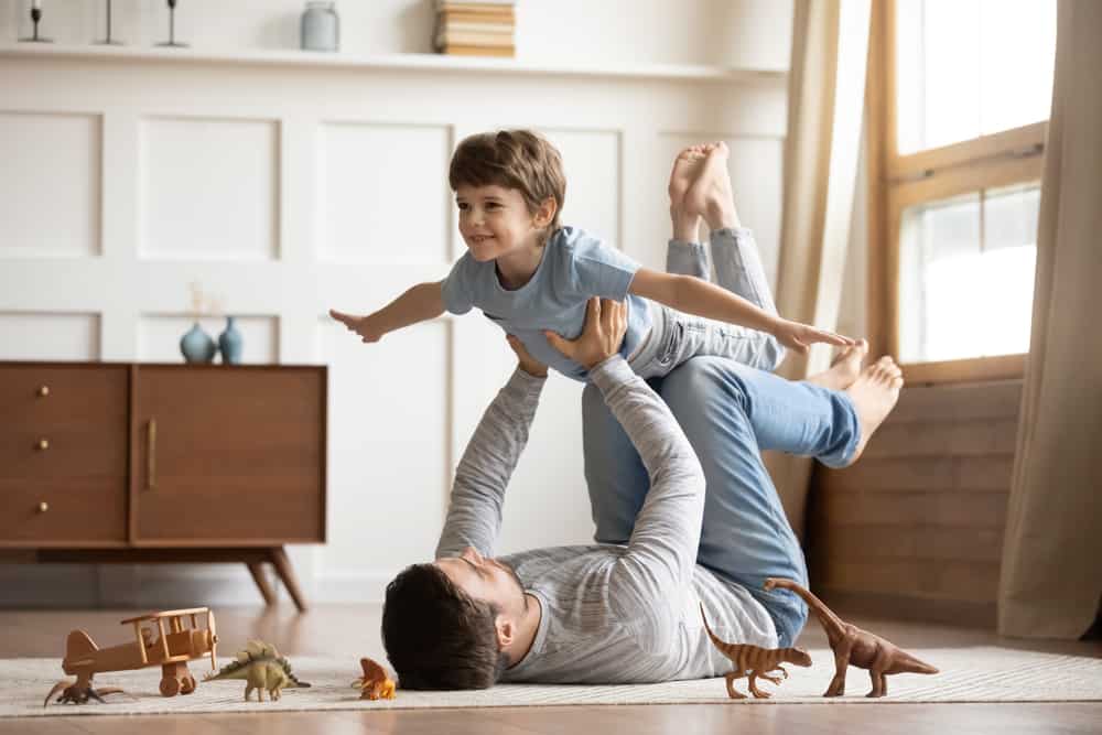 Dad playing aeroplanes with son